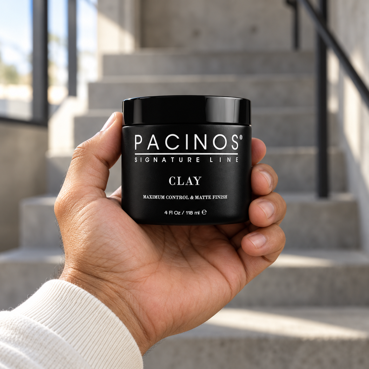 Pacinos Clay 4 oz jar held in a man's hand to show its size