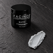 Pacinos Matte hair paste 4 oz jar beside a swipe of the light gray matte paste showing its dense, no-shine texture