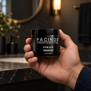 Pacinos Pomade 4 oz jar held in a man's hand to show its size